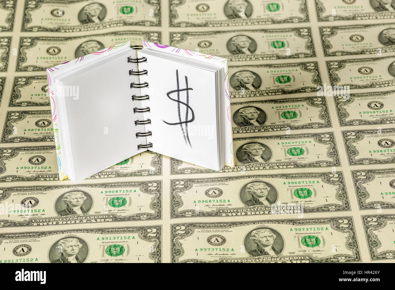 Blatt-Dollar-Scheine und ein Blatt Papier mit einem Geld-Schild Stockfoto