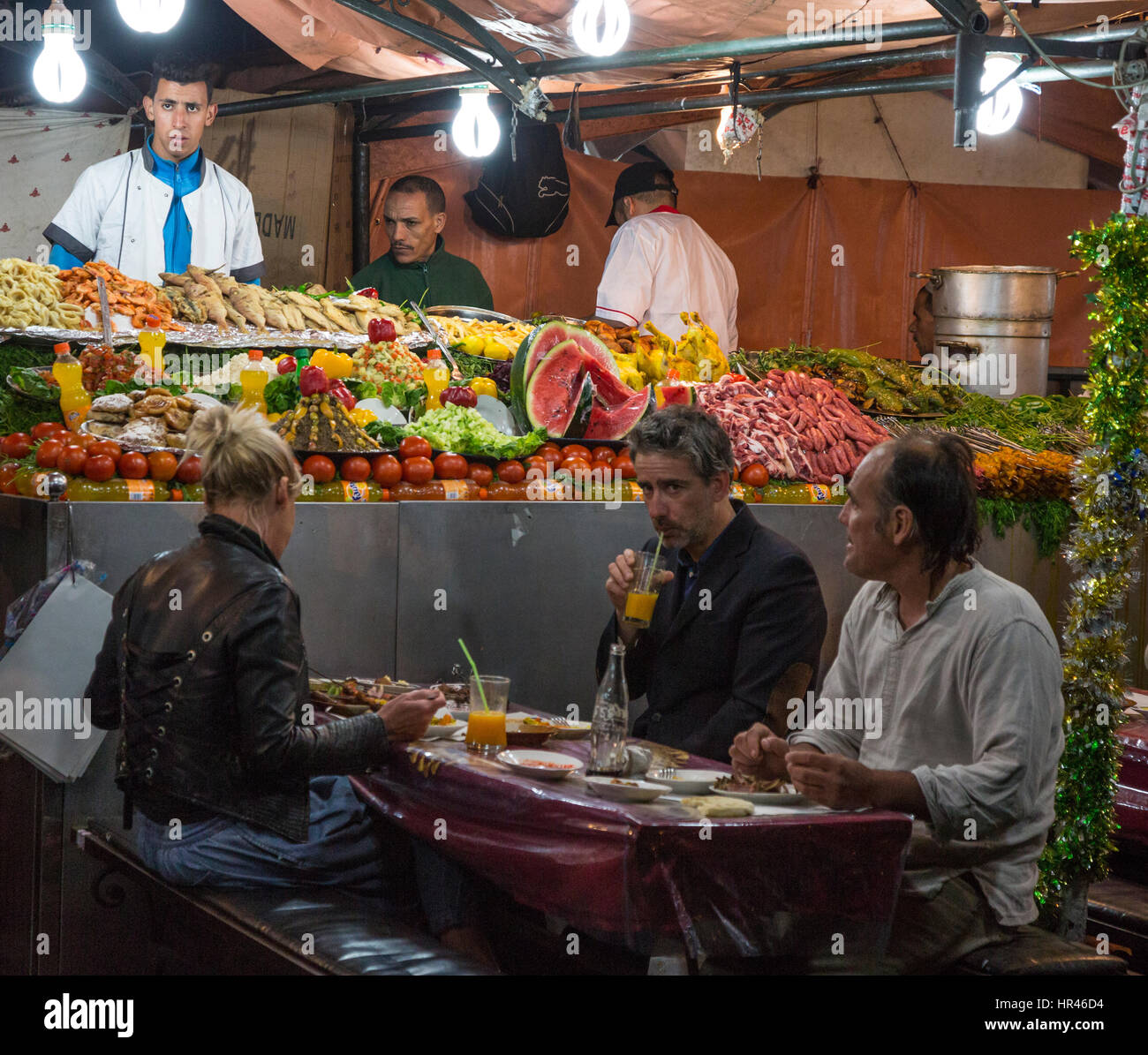 Marrakesch, Marokko. Touristen in Garküche, Essen Platz Djemaa El-Fna. Stockfoto