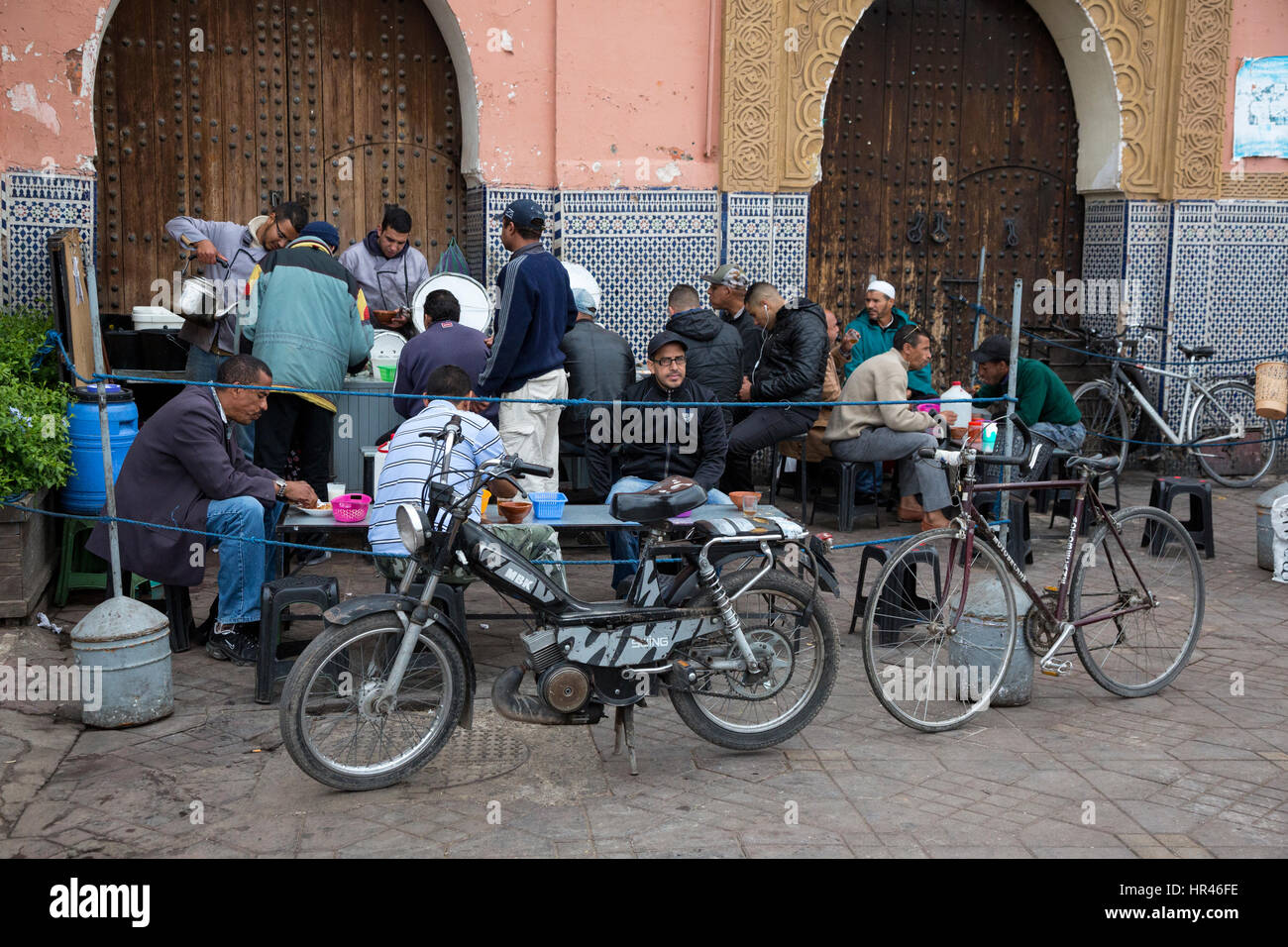 Marrakesch, Marokko.  Männer Essen auf einem Bürgersteig Erfrischung Stand. Stockfoto