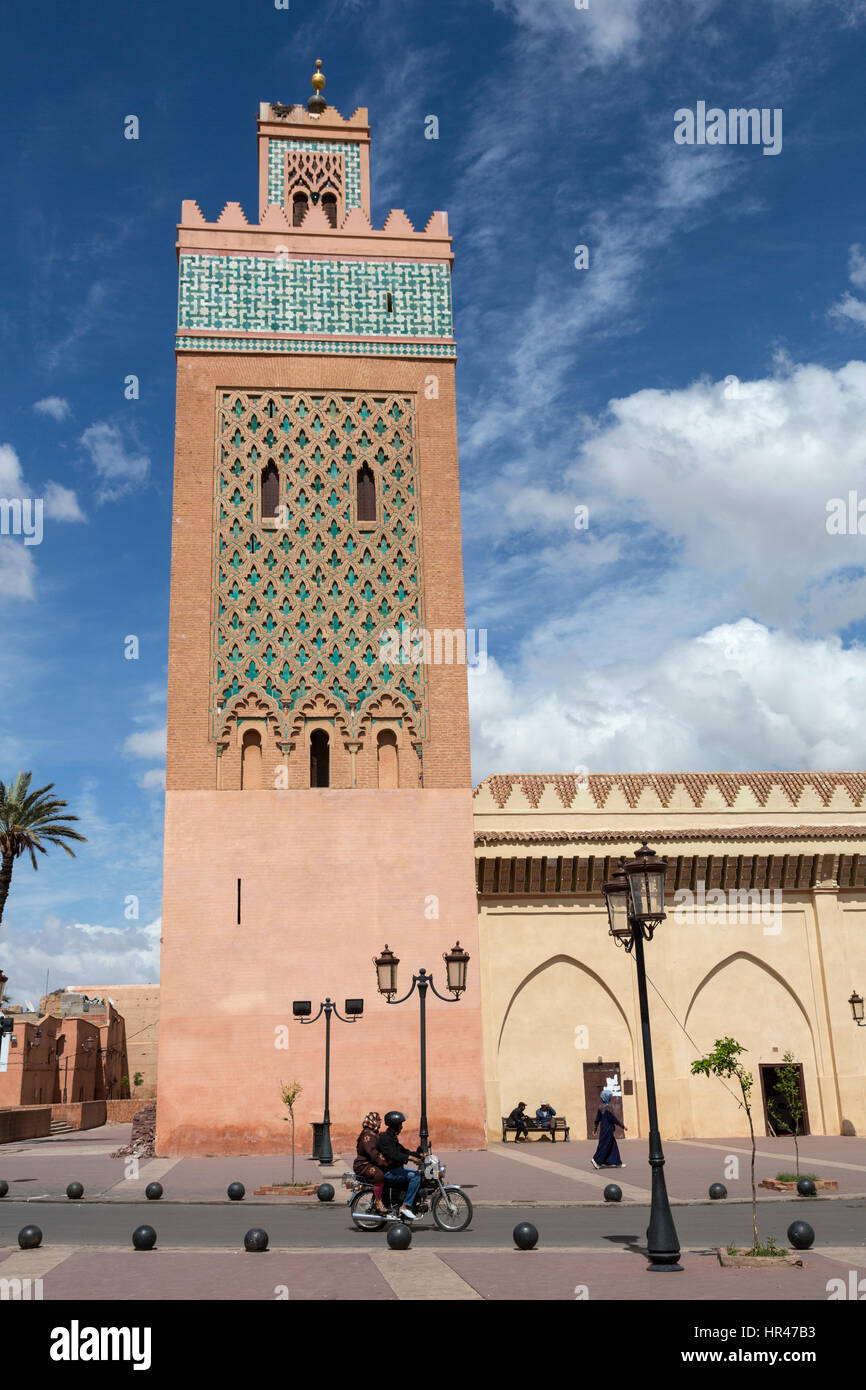 Marrakesch, Marokko. Paar auf Motorrad vorbei das Minarett der Moschee Moulay El Yazid. Stockfoto