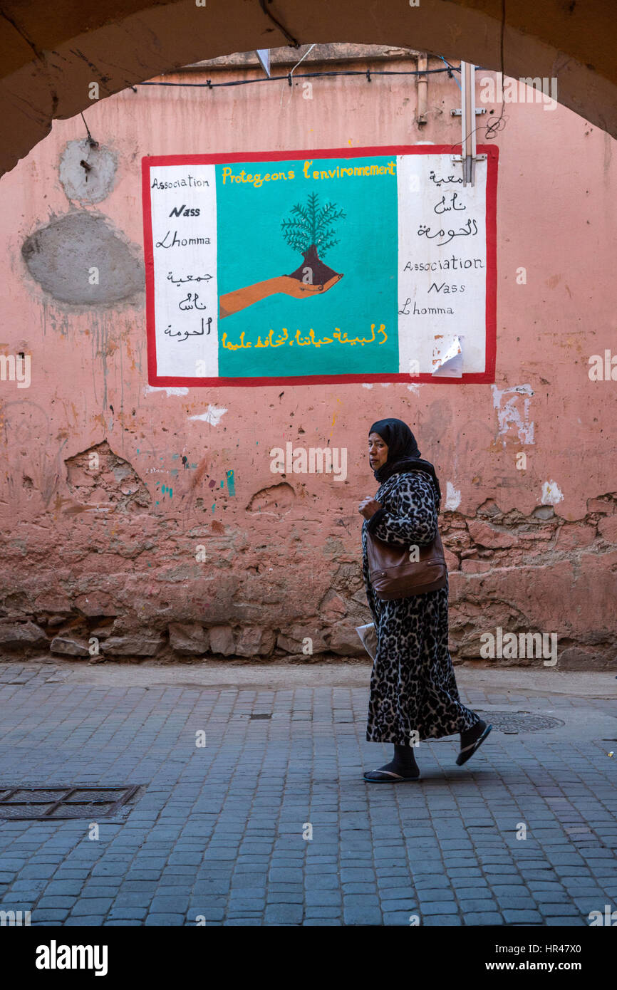 Marrakesch, Marokko.  Medina Straßenszene, Plakat fordert Schutz der Umwelt. Stockfoto