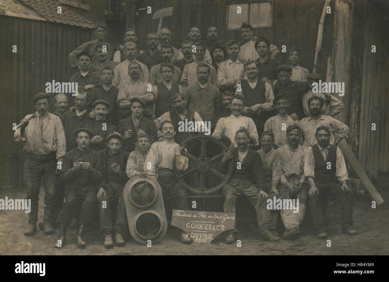 1911 antikes Foto G.Chokier & Co. Gießerei, Louvroil, Frankreich Arbeitnehmer mit Werkzeugen und ein Muster, Schimmel, Schimmel ein Zahnrad, Zahnrad, Zahnrad. Quelle: RPPC, real Photo Postkarte in Frankreich entdeckt. Stockfoto