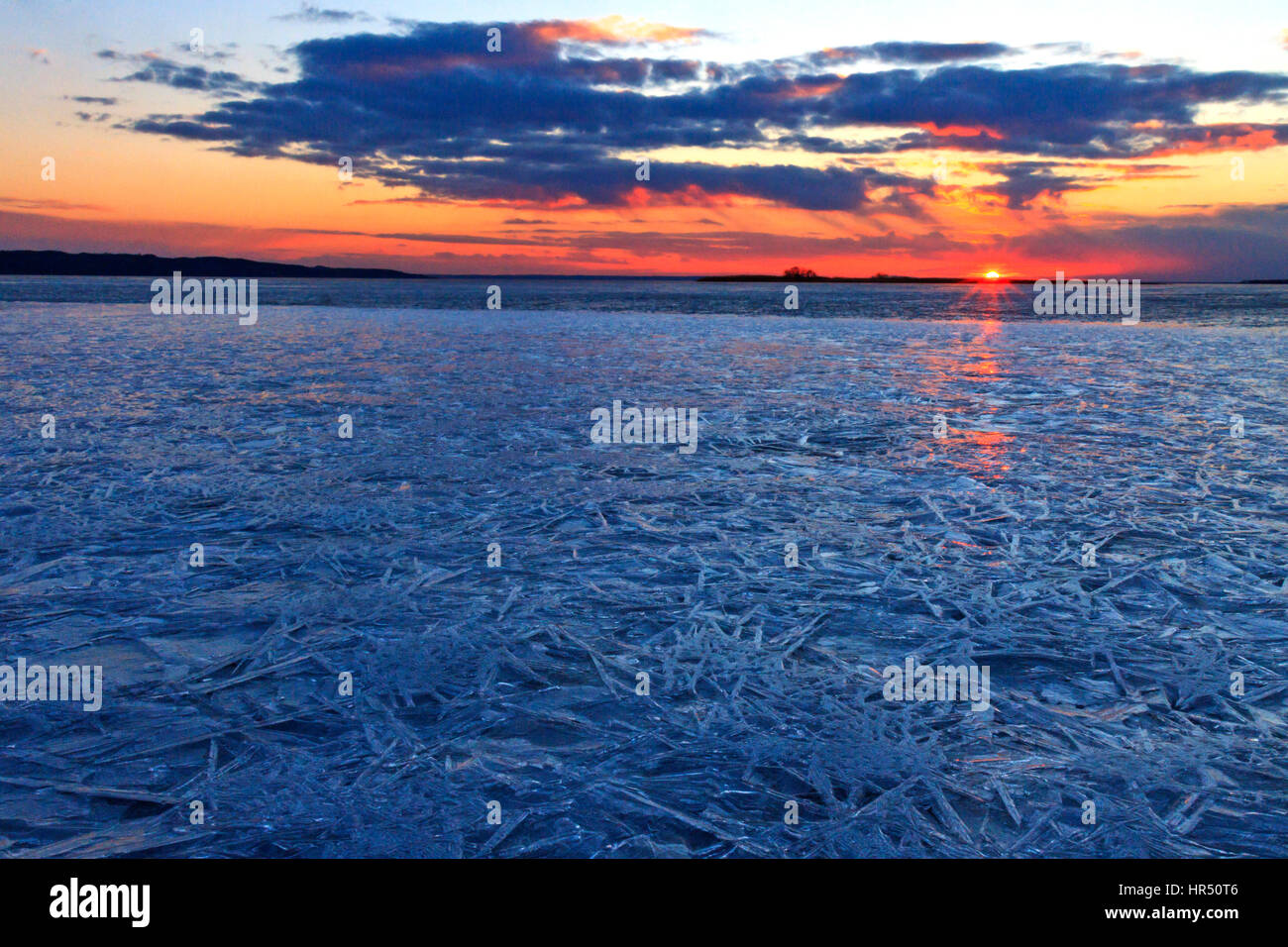 Sonnenuntergang über dem Fluss Eiskristalle gebunden, Frühling, Ende des Winter, Textur, Silhouetten, goldene Stunde, blaue Stunde Stockfoto