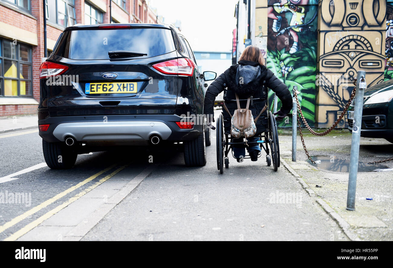 Rollstuhl Benutzer Kämpfe vorbei schlecht geparkten Auto auf Bürgersteig und doppelte gelbe Linien in Brighton UK Stockfoto