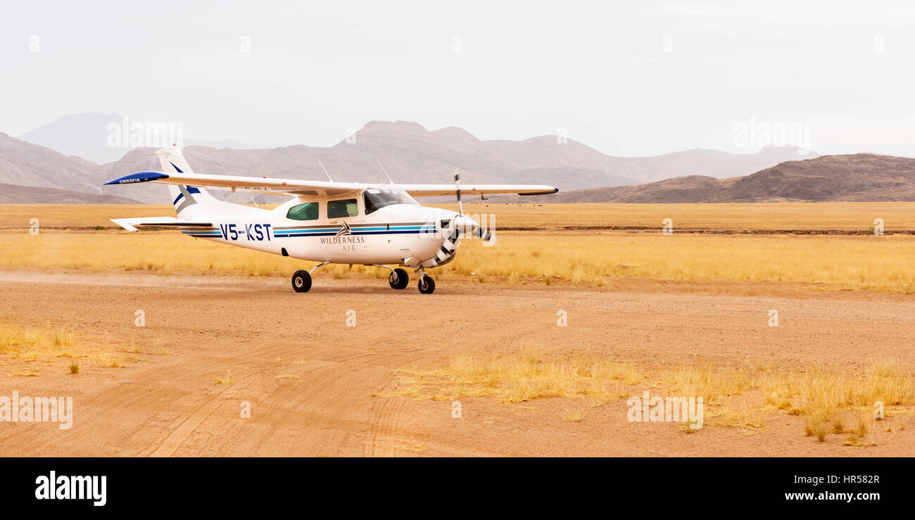 Eine Cessna 210 Landung auf dem Flugplatz in der Hartmann-Tal, Kaokoland, Nord West Namibia, dienen die Serra Cafema Wilderness Camp. Stockfoto