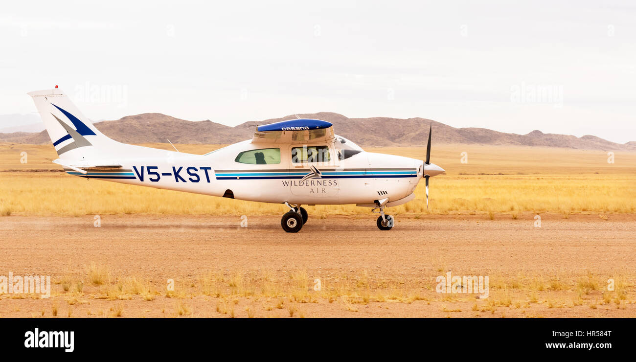 Eine Cessna 210 Landung auf dem Flugplatz in der Hartmann-Tal, Kaokoland, Nord West Namibia, dienen die Serra Cafema Wilderness Camp. Stockfoto