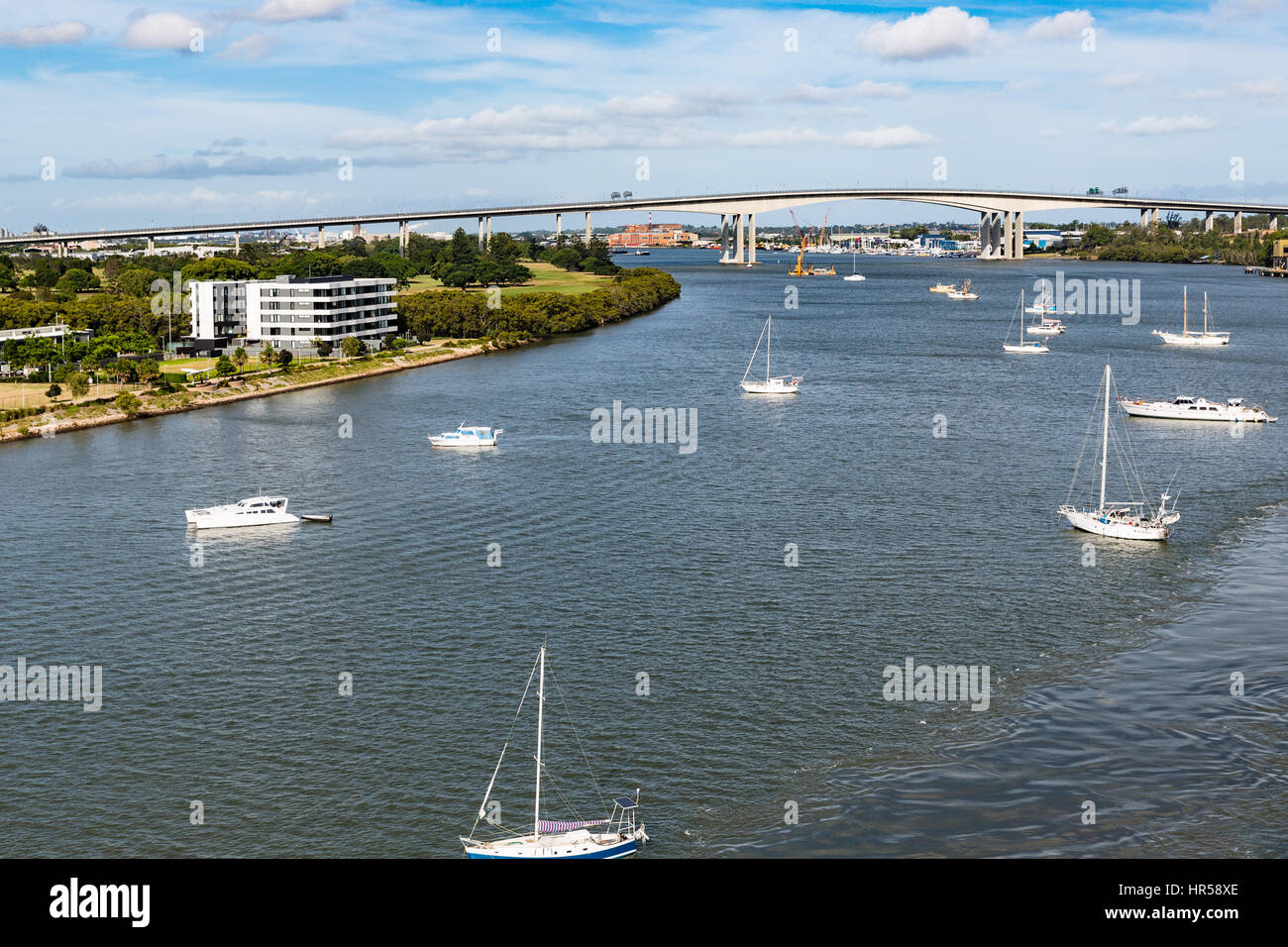 Freizeitboote vertäut im Brisbane River mit Gateway Bridge im Hintergrund Stockfoto