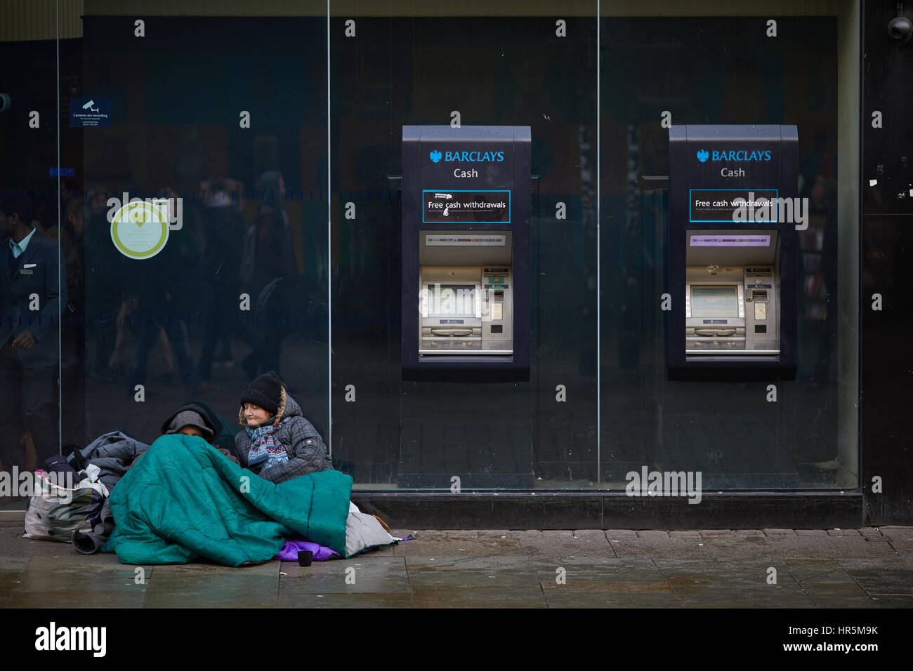 Barclays Bank außen Manchester Market Street Obdachlosen paar sitzen in der Nähe von ATM Geldautomaten England, UK. Stockfoto