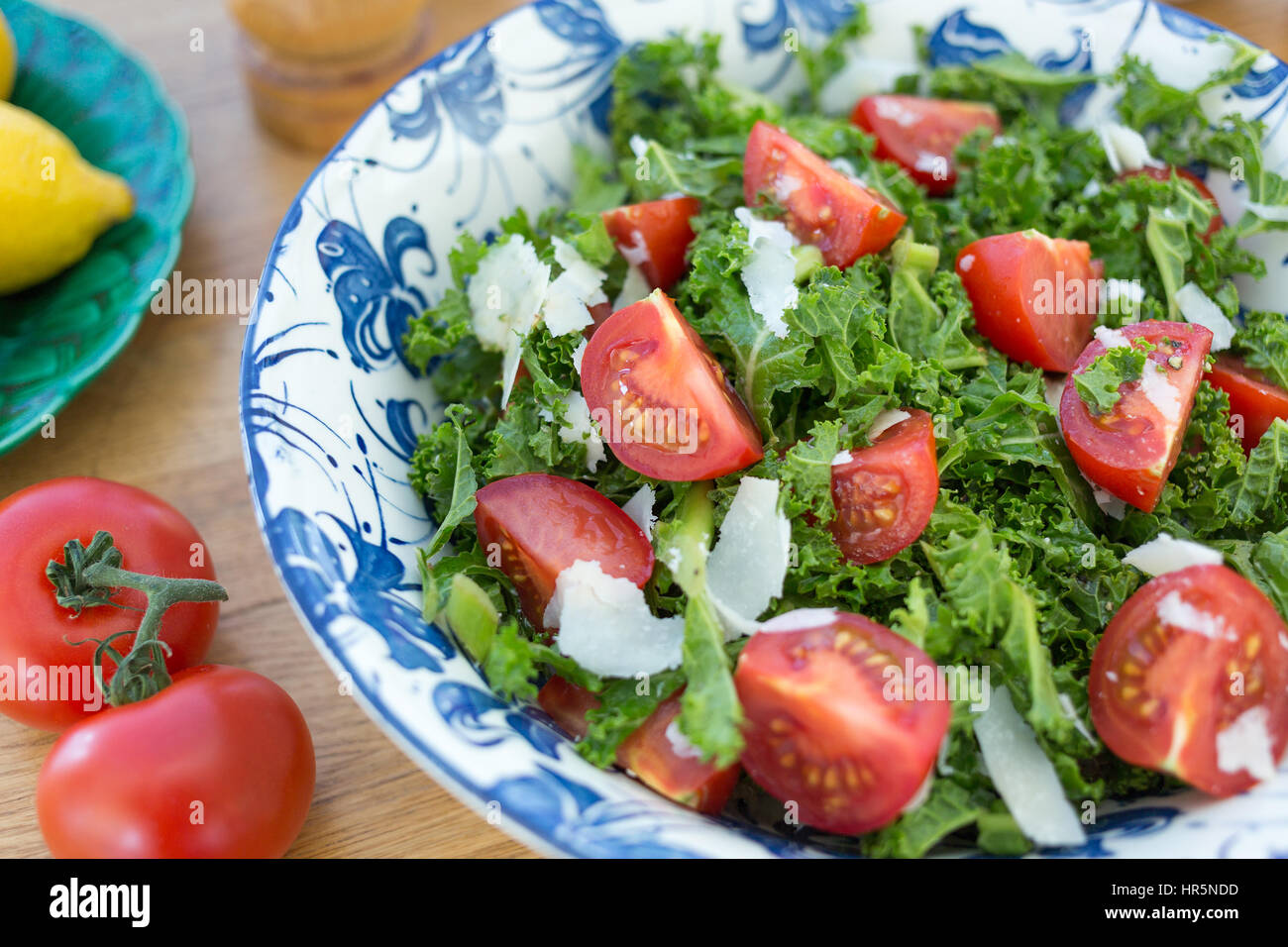 Schüssel mit Grünkohl und Tomaten-Salat mit gehobeltem Parmesan Käse. Stockfoto