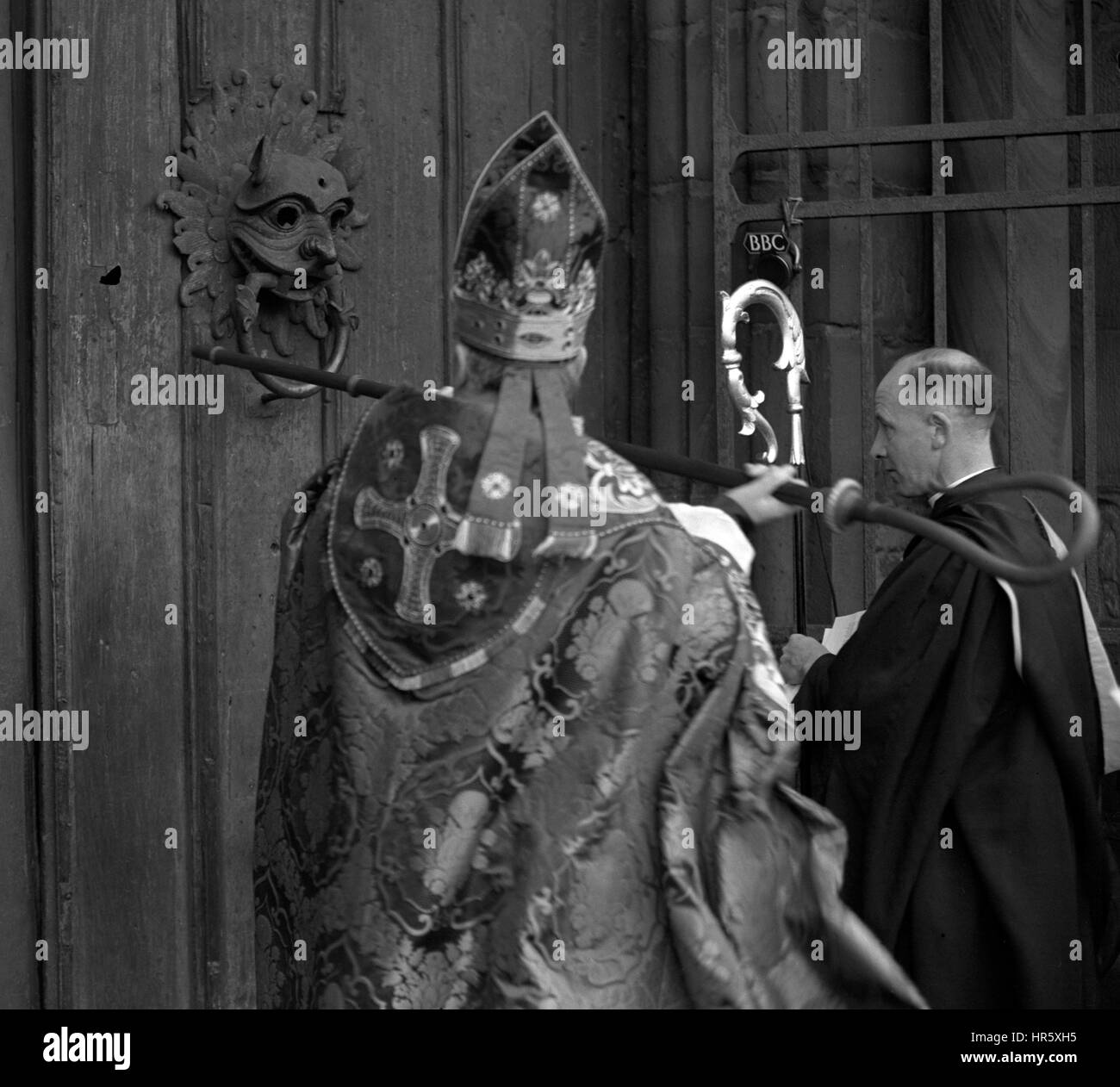 Der neue Bischof von Durham, Dr. Arthur Michael Ramsey, schlägt dreimal auf die massive Wasserspeier geschmückt Tür der Kathedrale von Durham auf Nachfrage Zulassung bei seiner Inthronisation. Stockfoto