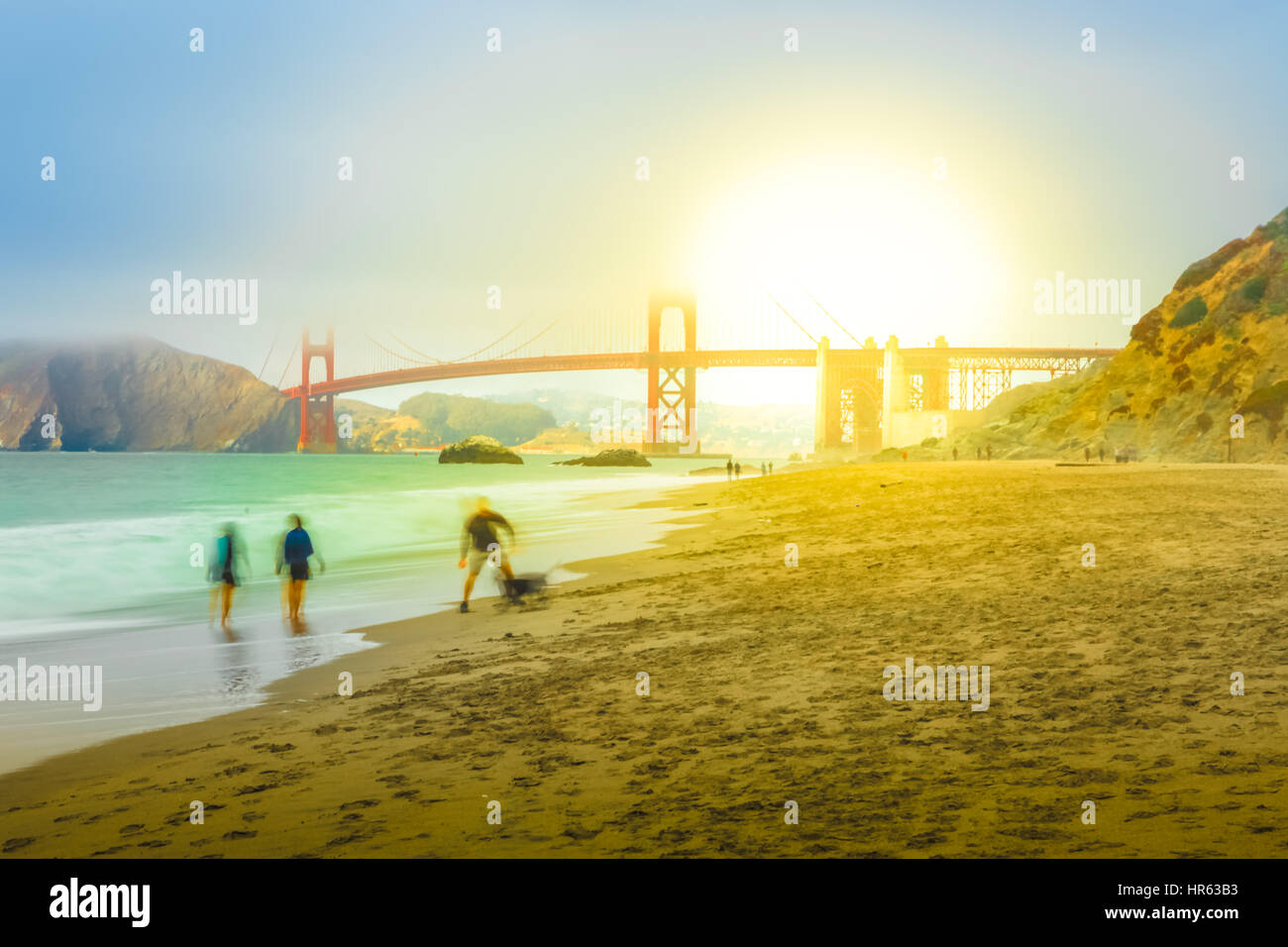 Golden Gate Bridge in Baker Beach bei Sonnenuntergang. Touristen gehen und spielen mit Hund auf beliebte Baker Beach. Urlaub, Reisen und Freizeit in San Francis Stockfoto