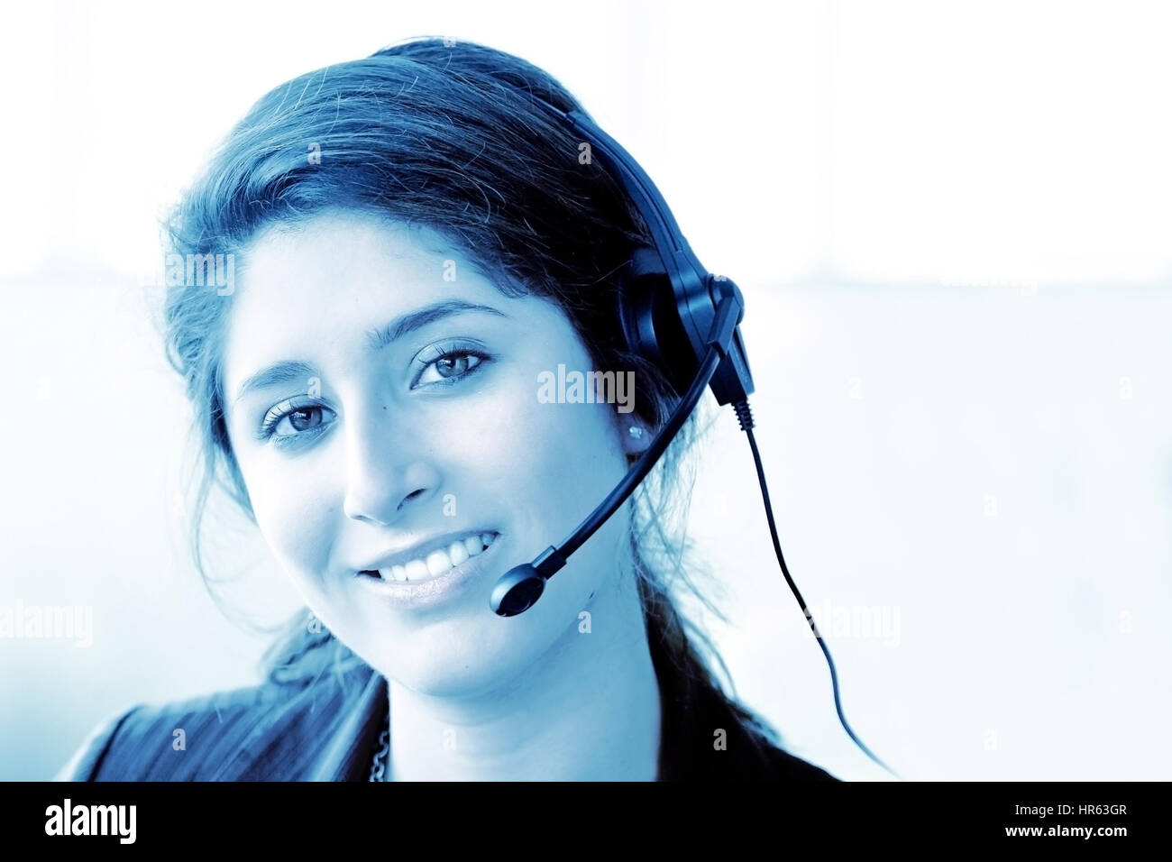 Kunden Support Center Frau in einem Büro lächelnd - blaue Töne Stockfoto