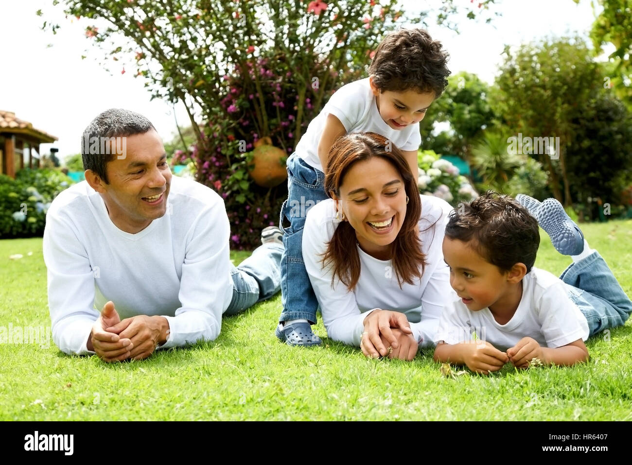 glückliche Familie lächelnd in ein Porträt von einer Mama und Papa mit ihren zwei Kindern Stockfoto