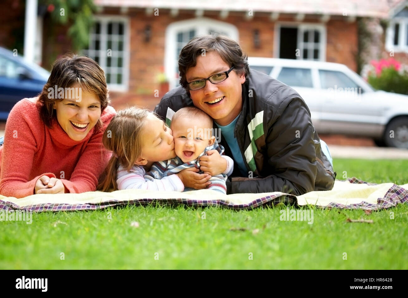 glückliche Familie lächelnd in ein Porträt von einer Mama und Papa mit ihren zwei Kindern Stockfoto