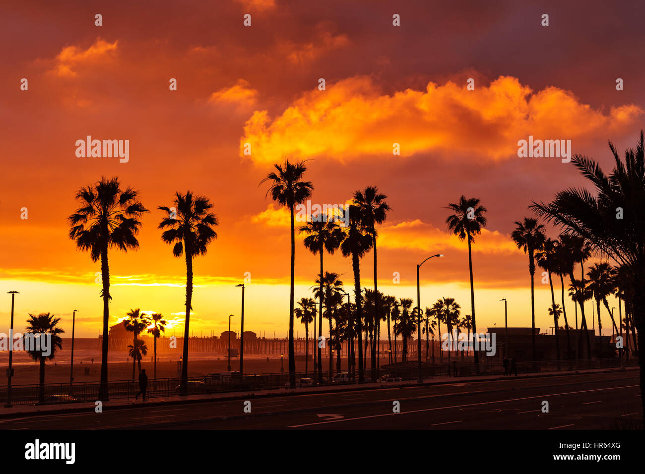 Farbenfroher Sonnenuntergang mit Palmen in Silhouette in Huntington Beach, Kalifornien, USA Stockfoto