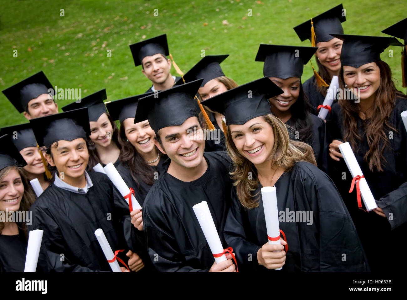 Gruppe von Studenten der Graduierung im Park suchen glücklich Stockfoto