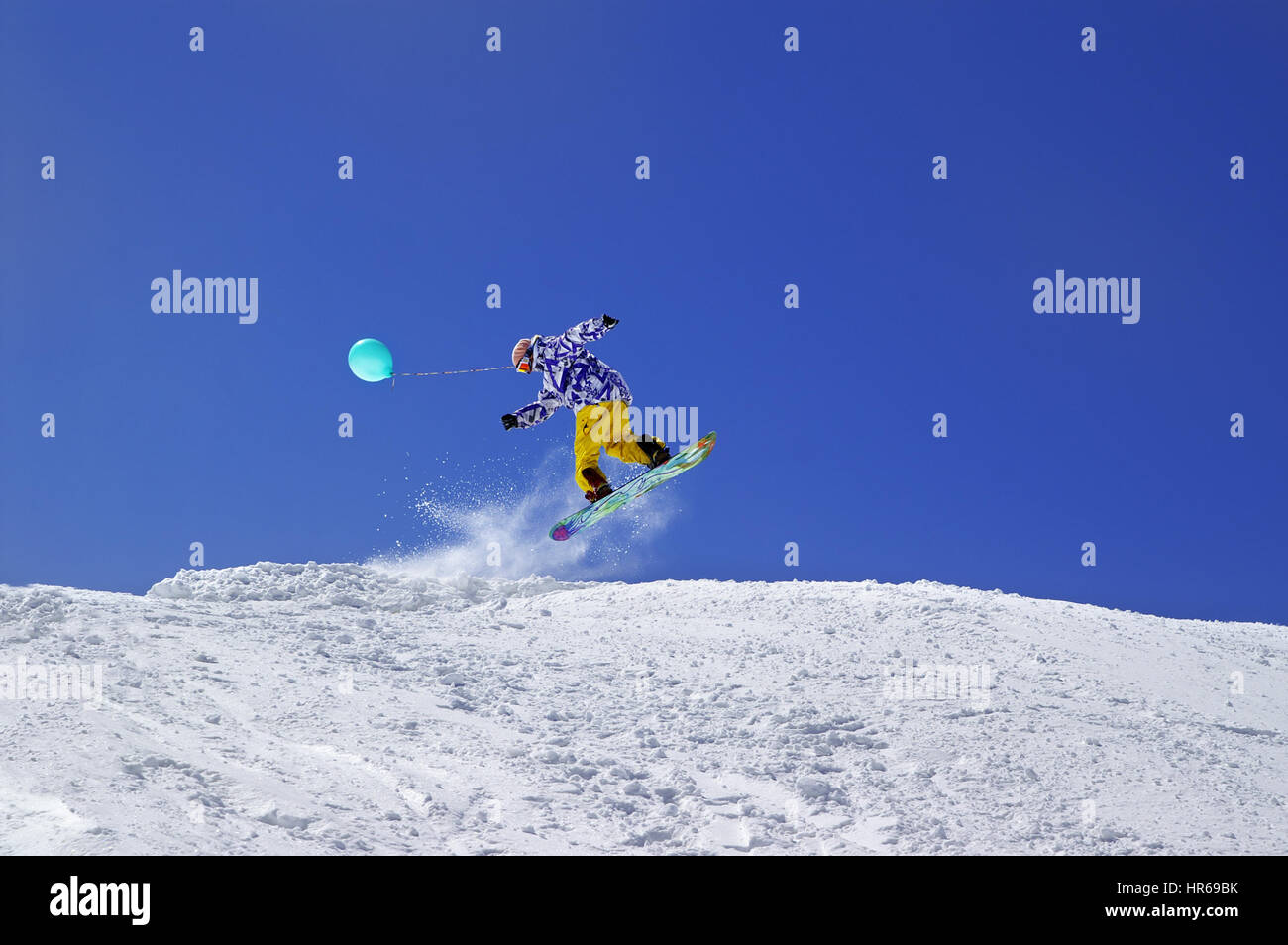 Snowboarder springen mit Spielzeug Ballon im Funpark im Skigebiet auf Sonne Wintertag. Kaukasus-Gebirge, Region Dombay. Stockfoto