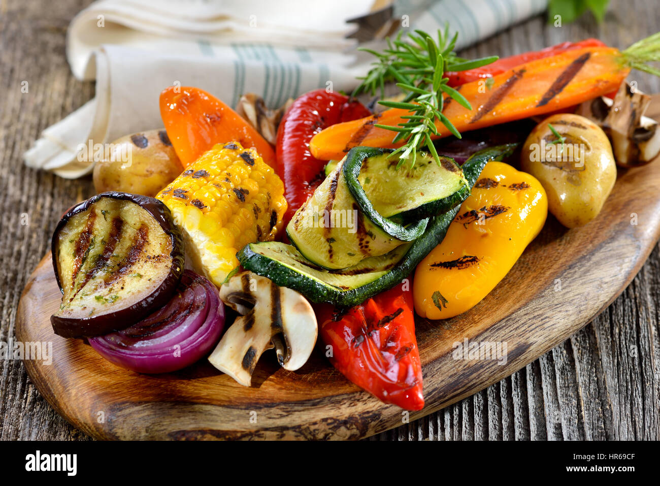 Vegane Küche: gemischtes gegrilltes Gemüse auf einem Holzbrett Stockfoto