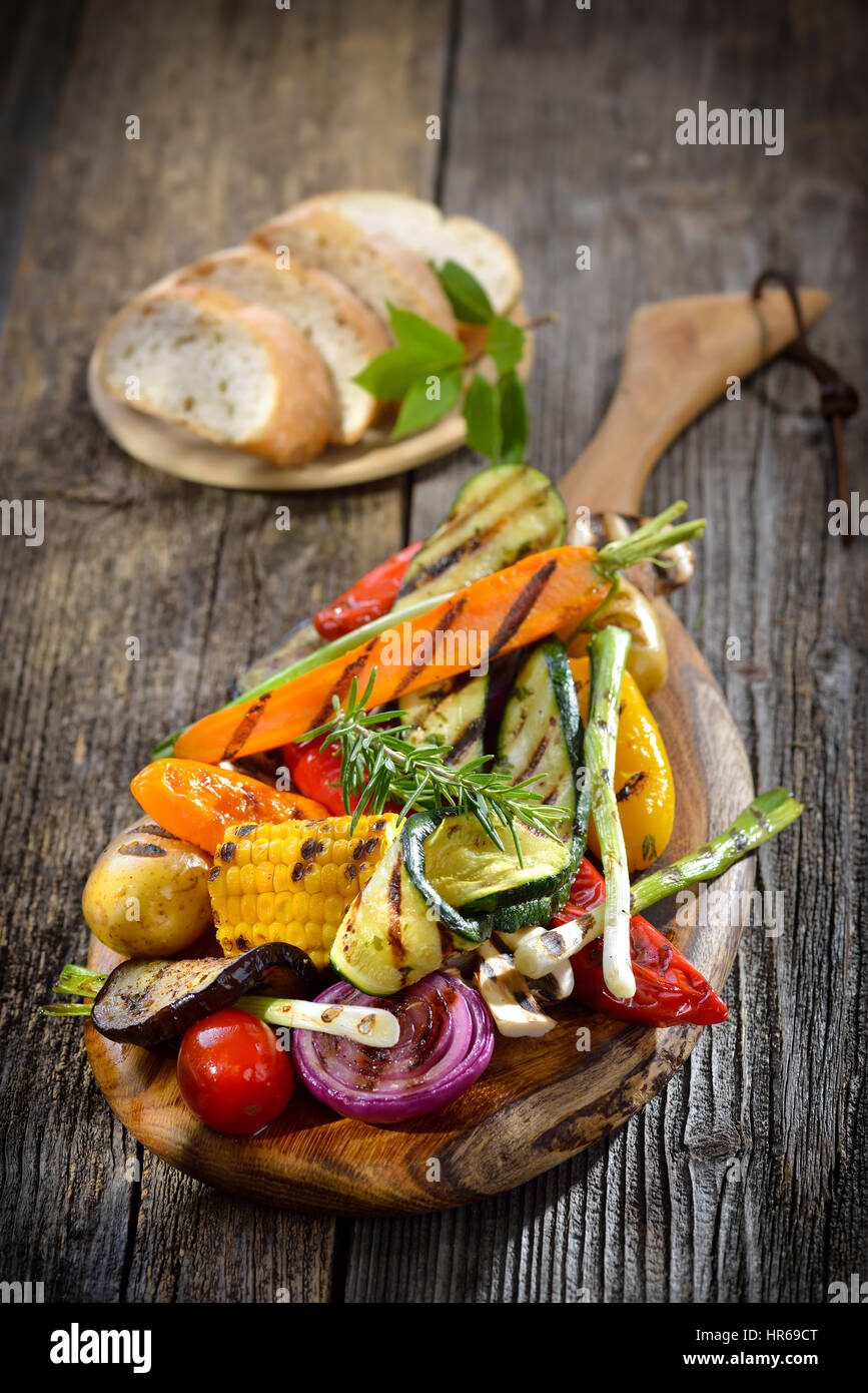Vegane Küche: Gegrilltes Gemüse auf einem Holzbrett serviert mit italienischen Ciabatta Brot Stockfoto