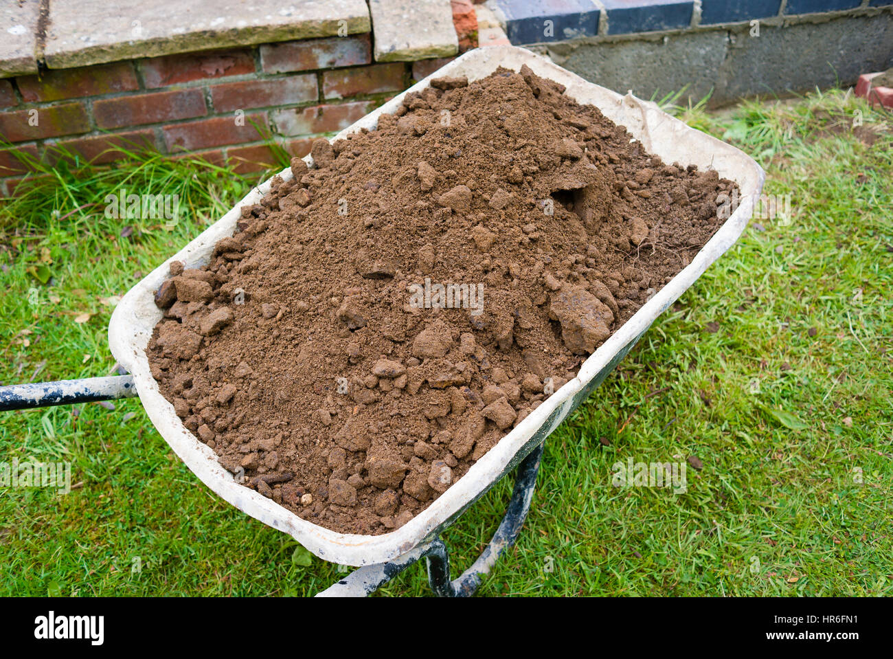 Schubkarre gefüllt mit Beute aus einem neuen Outdoor-Teich gegraben Stockfoto