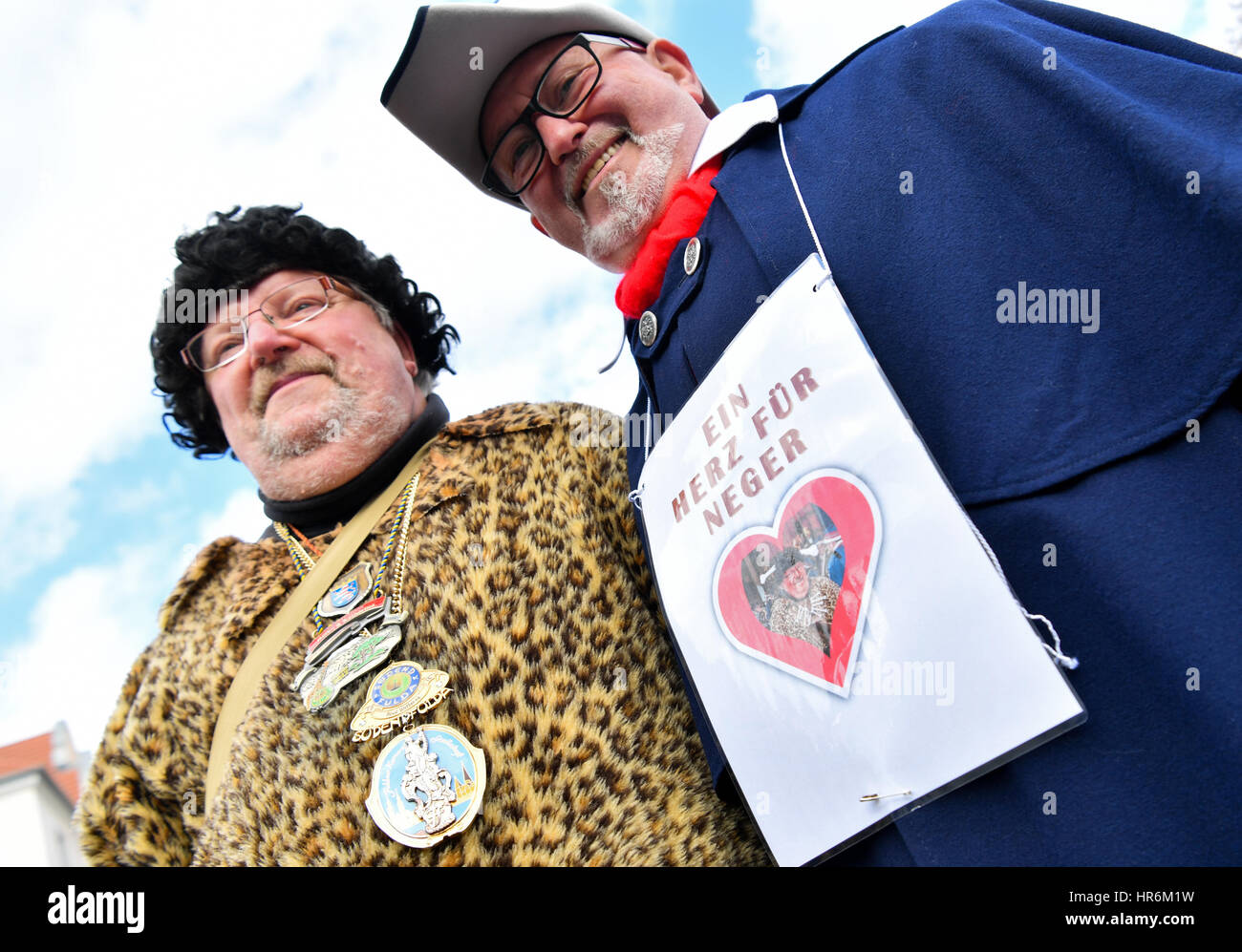 Fulda, Deutschland. 27. Februar 2017. Wolfgang Schuster (l) des Vereins  Karneval Suedend-Fulda neben Martin Kessler des Vereins Karneval  "Brunnenzecken Fulda steht" trägt ein Schild, das liest "Ein Herz Fuer  Neger" (lit.) "Ein