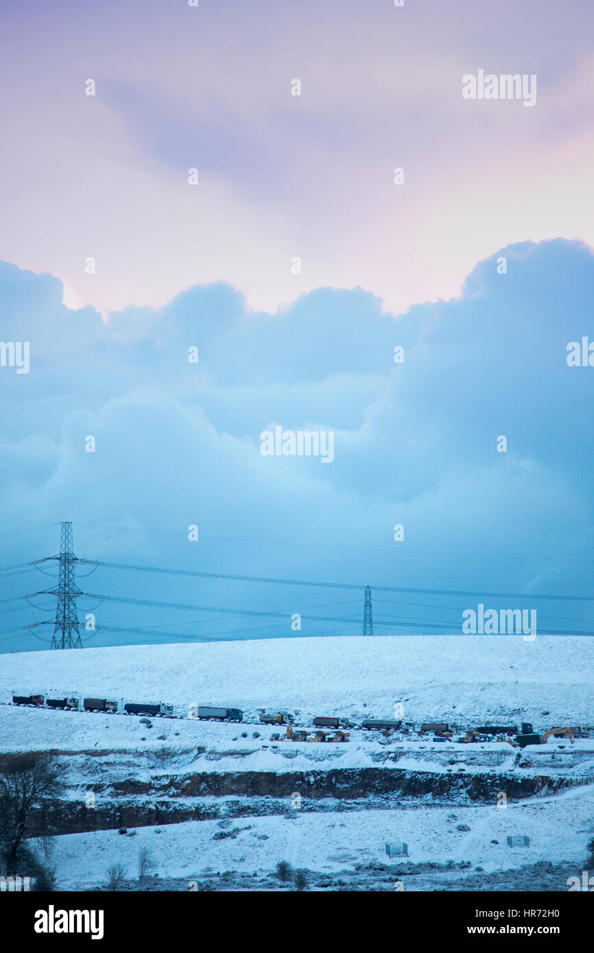 North Wales, UK. . Über Nacht die Temperatur unter dem Gefrierpunkt mit Schnee Duschen über North Wales Verlassen einer frischen Schneedecke von ein paar Zentimeter für Dörfer in Flintshire. Schnee und Sturm Wolken über dem Dorf Rhes-y-Cae, Flintshire, da der Verkehr ist mit einem Stand noch Stockfoto