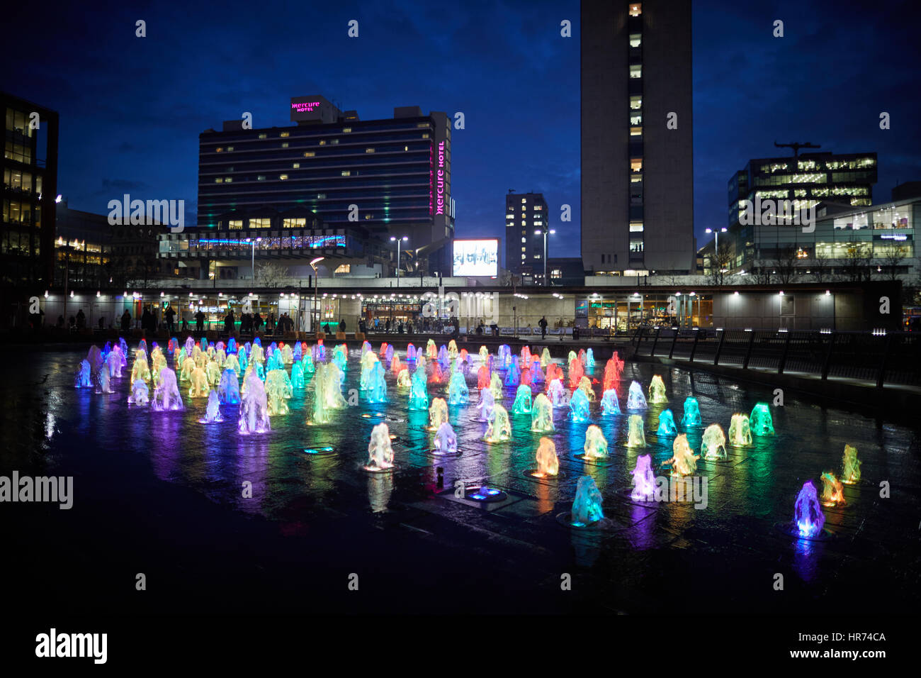 Stadtzentrum von MANCHESTER Piccadilly Gardens Wahrzeichen Wasserfontäne Anzeige leuchtet nachts. Stockfoto