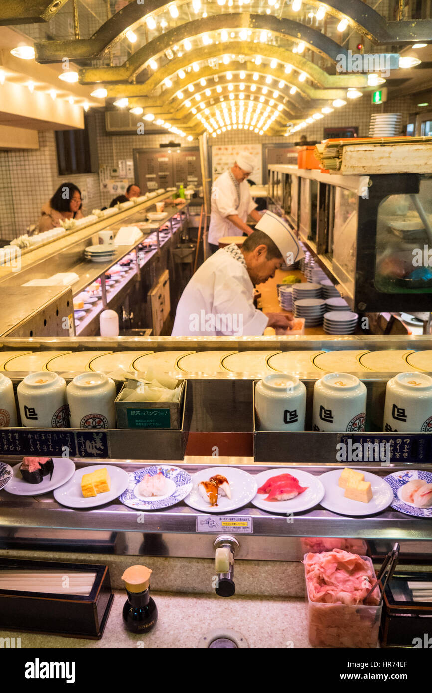 Ein Sushi-Restaurant, wo das Essen auf einem Sushi-Zug in Shinjuku, Tokio, Japan präsentiert wird. Stockfoto