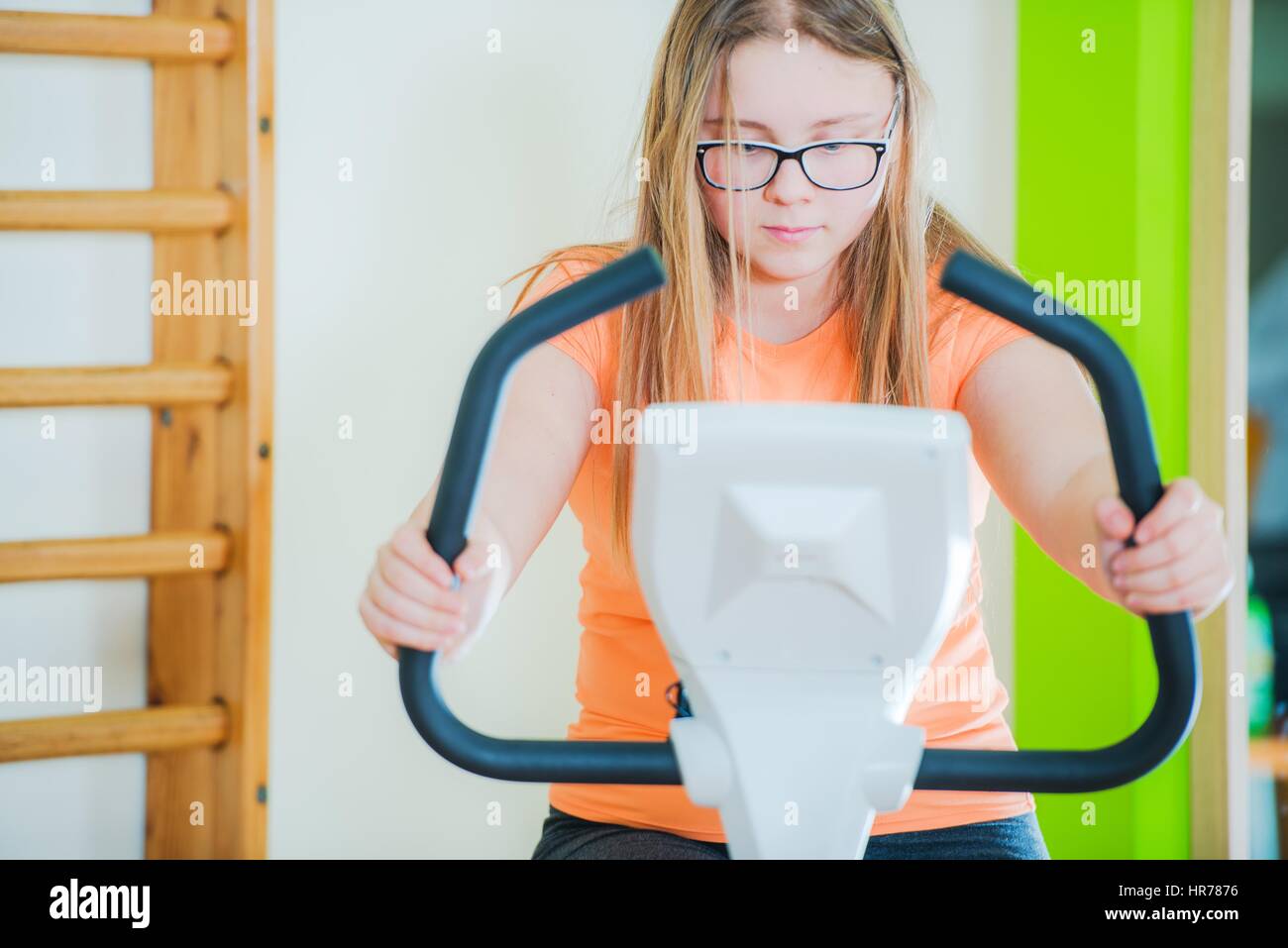 Teenager-Mädchen auf Heimtrainer im Fitness-Center. Nahaufnahme Foto. Stockfoto