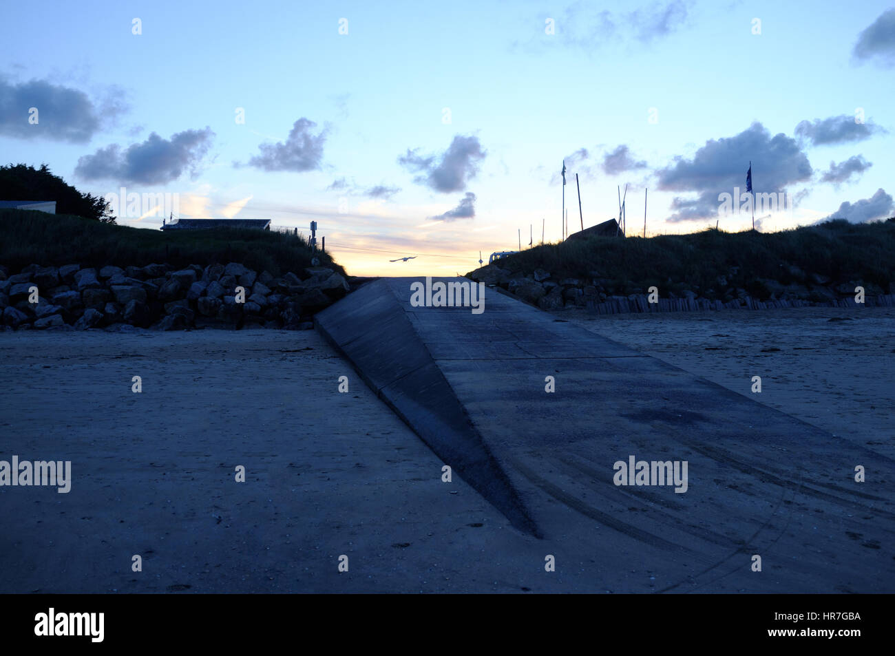 Ein Flug einer Möwe in den blauen Stunden des Sonnenuntergangs in Utah Beach, Normandie, Frankreich Stockfoto