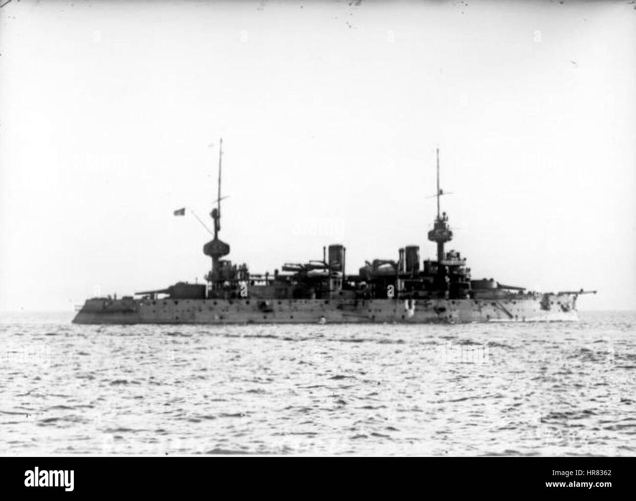 Suffren in Toulon von Agence Rol zeigt den französischen Marinekommandeur Suffren während eines bedeutenden Marinestuhs in Toulon, Frankreich. Das Gemälde fängt die Stärke und Entschlossenheit des Kommandeurs inmitten der Militärszene ein. Stockfoto