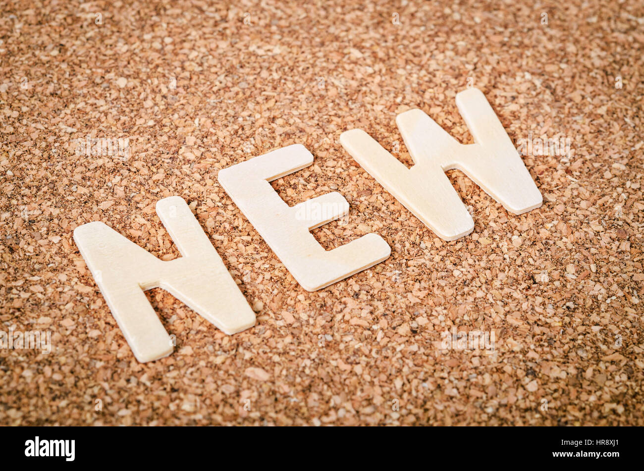 NEUES Wort Alphabet Holz auf Holz Hintergrund. Stockfoto