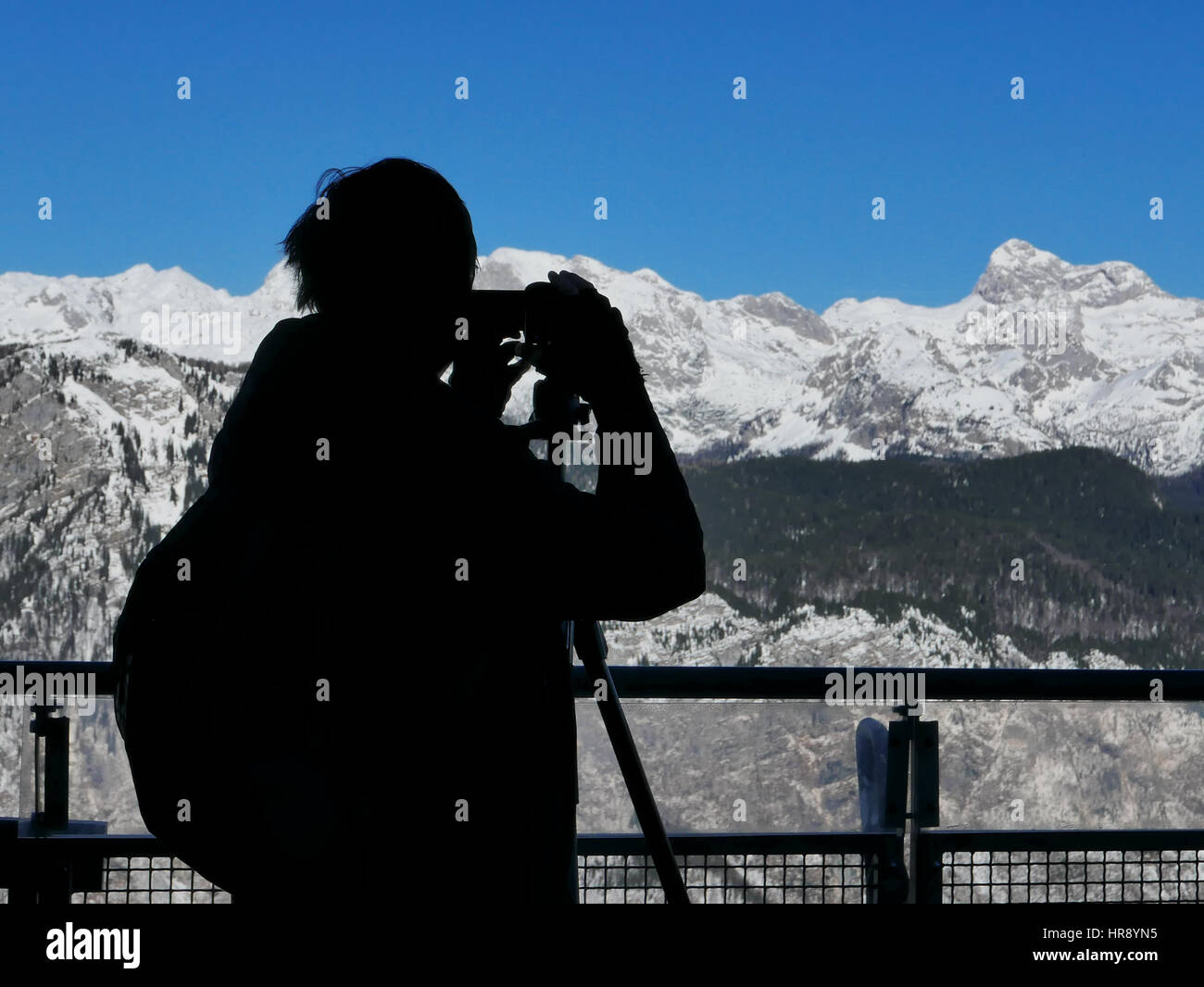 Silhouette des männlichen Landschaftsfotografen Erfassung atemberaubenden Blick auf Schnee begrenzt Gebirge Stockfoto
