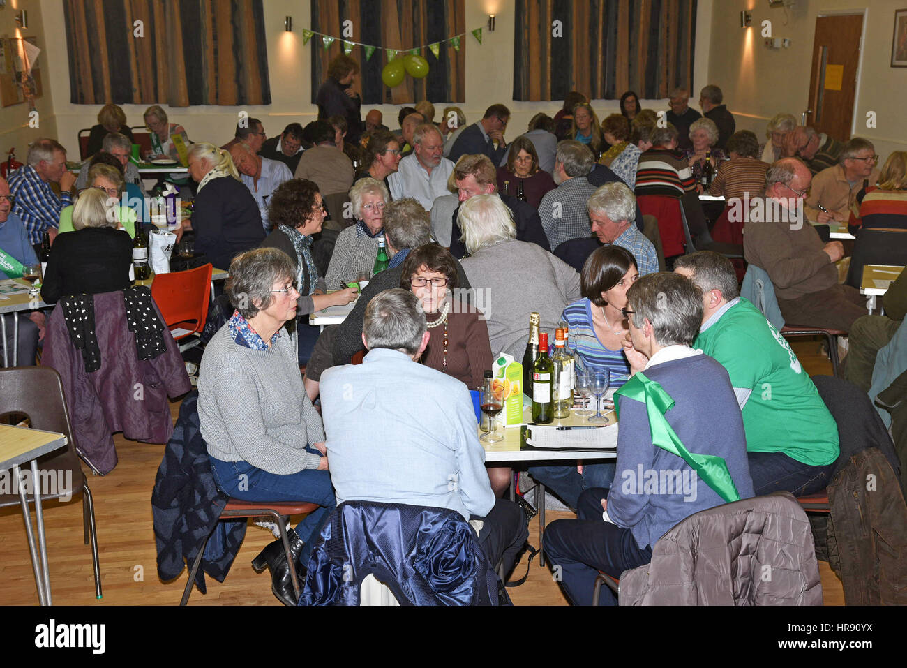 Menschen, die anlässlich einer Funktion in einer überfüllten Dorfhalle im Bigbury in Devon England UK Stockfoto