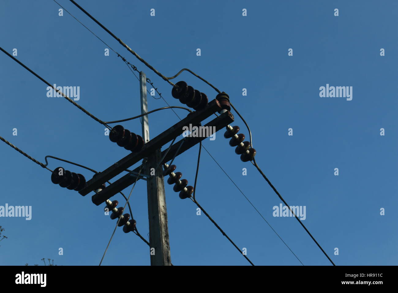 Stromleitungen und Polen gegen einen tiefblauen Himmel. Viel Platz für text Stockfoto