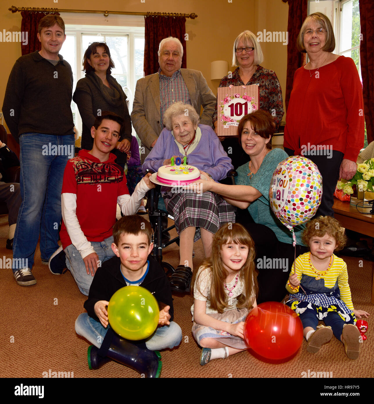 Seniorin im Rollstuhl ihren 101. Geburtstag feiert umgeben von ihrer Familie und Mitarbeiter im Pflegeheim, Alton, UK. Stockfoto