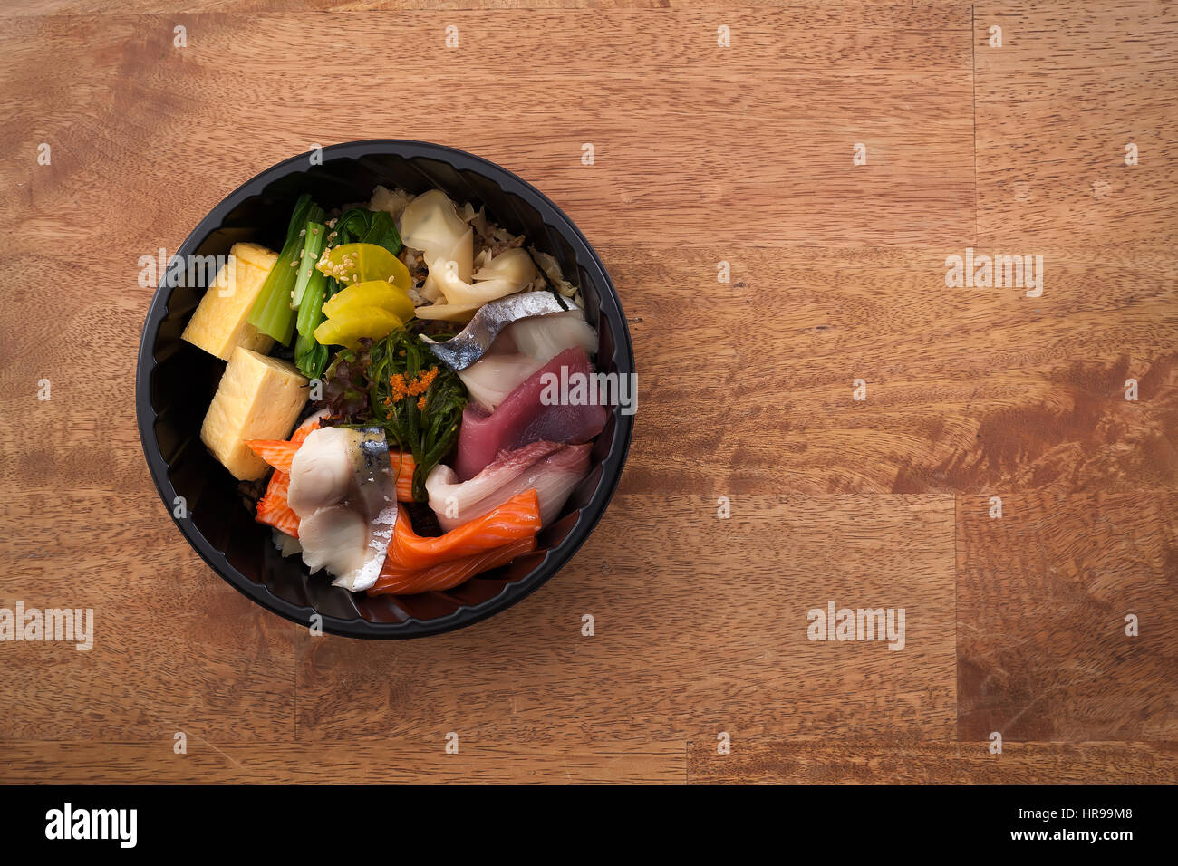 Japanisches Essen Tekka Don zum mitnehmen auf hölzernen Hintergrund rohen Thunfisch Lachs Otoro Algen Reis Stockfoto