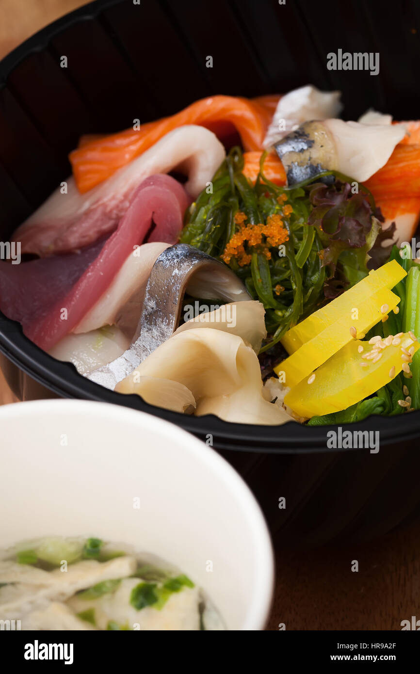 Japanisches Essen Tekka Don zum mitnehmen auf hölzernen Hintergrund rohen Thunfisch Lachs Otoro Algen Reis Stockfoto
