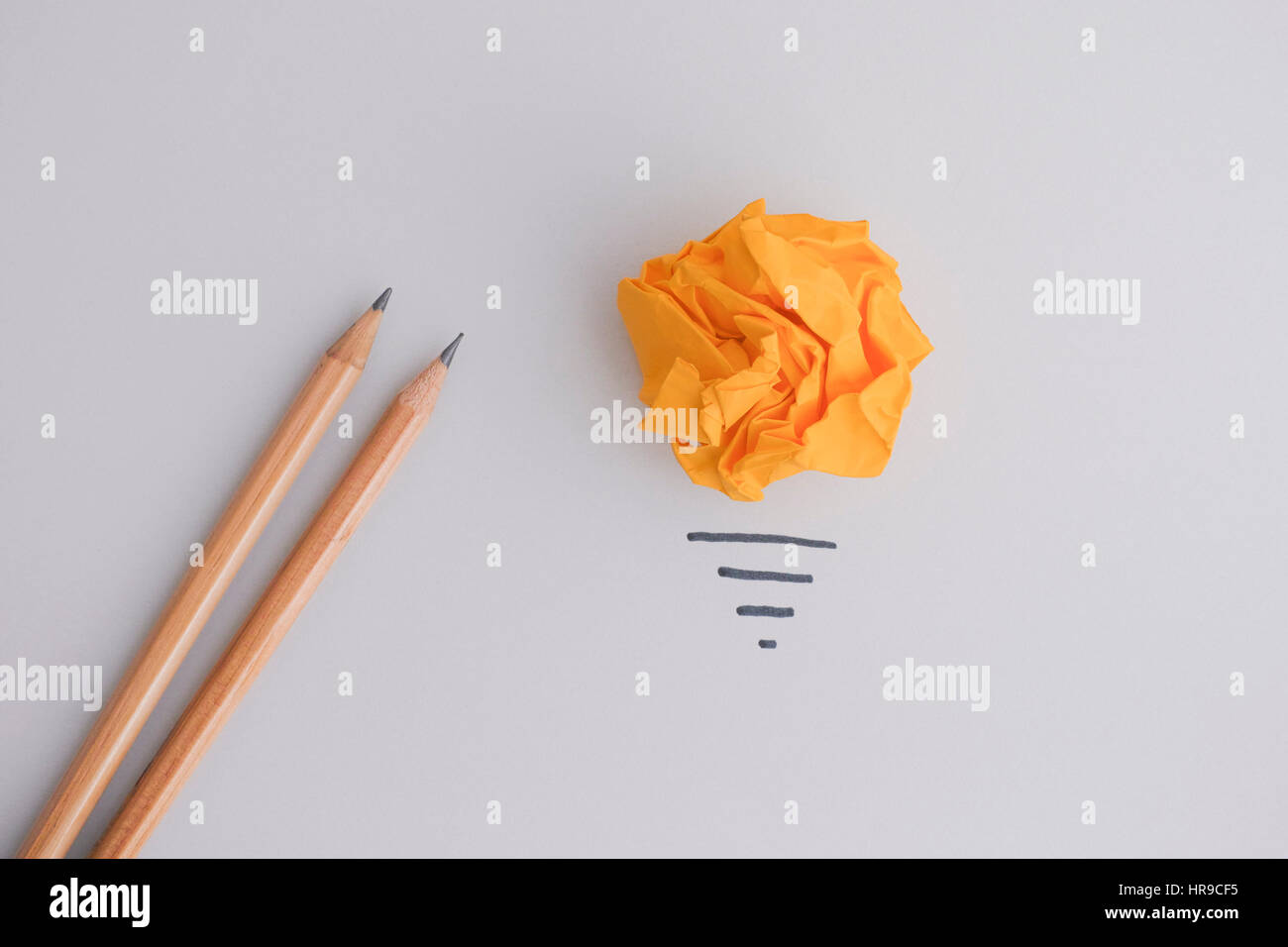 Auf der Suche nach neuen Idee oder Innovation. Gelbe zerknittertes Papier Ball als eine Glühbirne und zwei Bleistifte. Stockfoto
