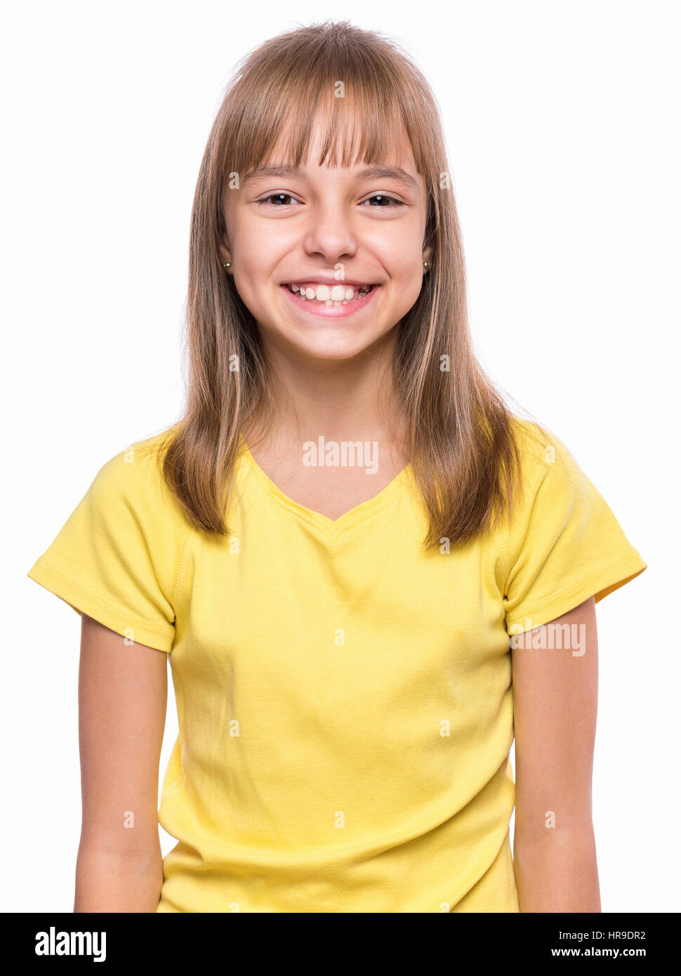 Emotionale Brustbild des Kaukasischen Mädchen mit gelben T-shirt. Glücklich Schulmädchen Blick in die Kamera und lachen. Lustige süßes lächelndes Kind ist Stockfoto