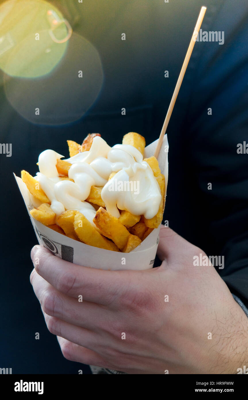 Hand, die Pommes Frites mit Mayonnaise Stockfoto