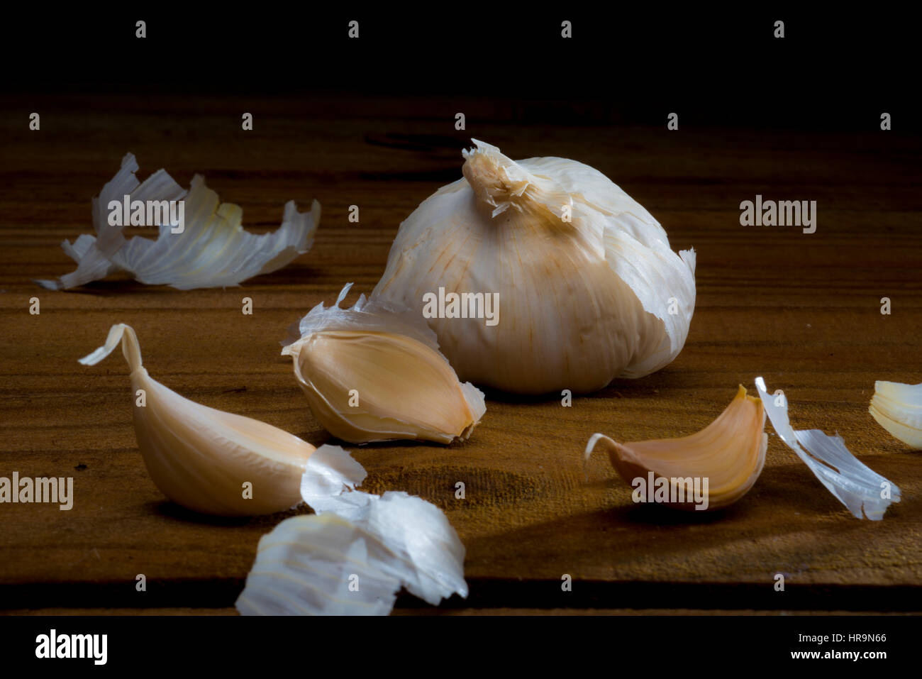 Knoblauchzehe und Stücke auf Holztisch Stockfoto
