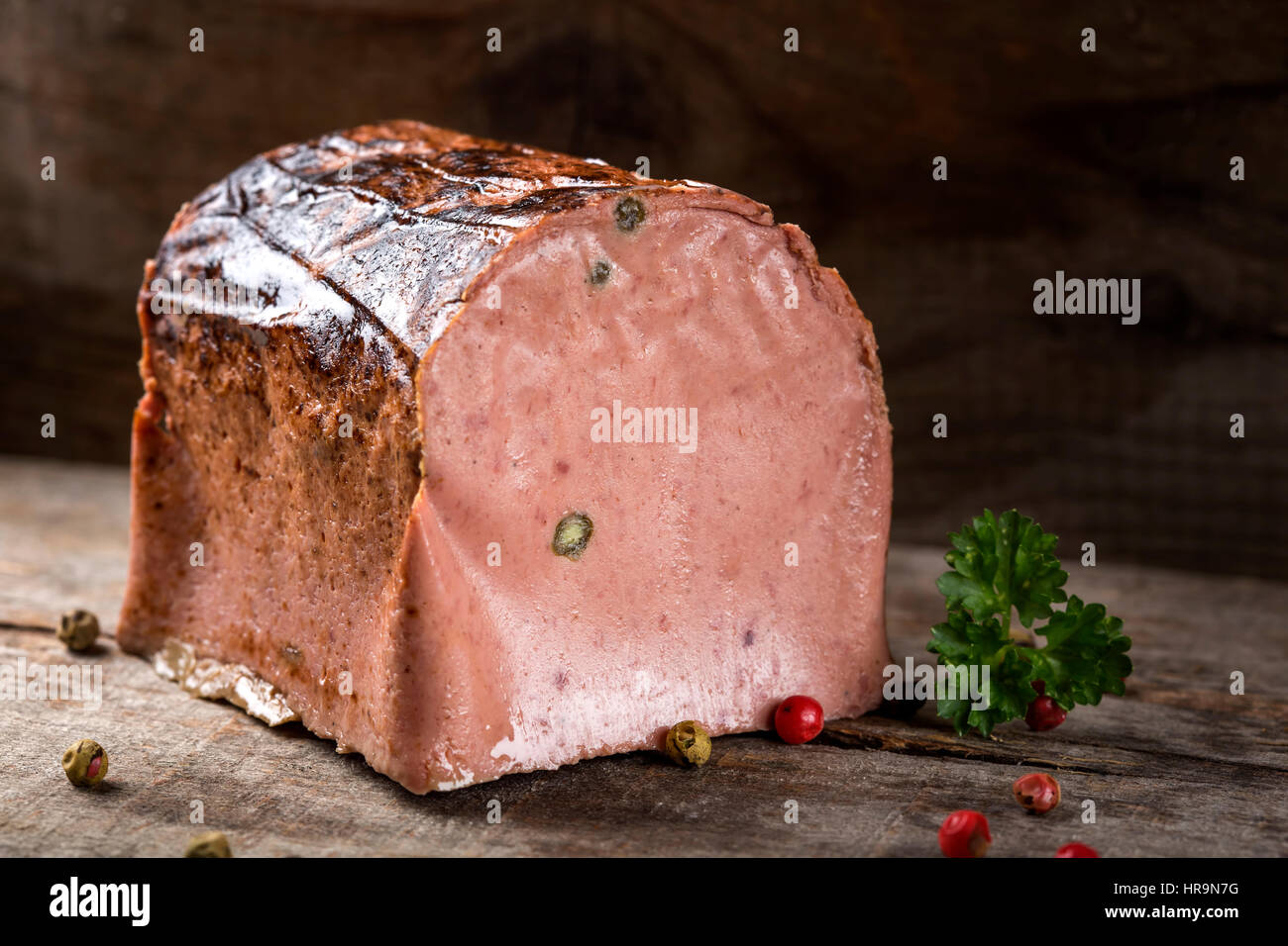 Spezielle Leberpastete gemacht aus verschiedenen Arten von Fleisch mit Pfefferkörnern auf Holz Hintergrund Stockfoto