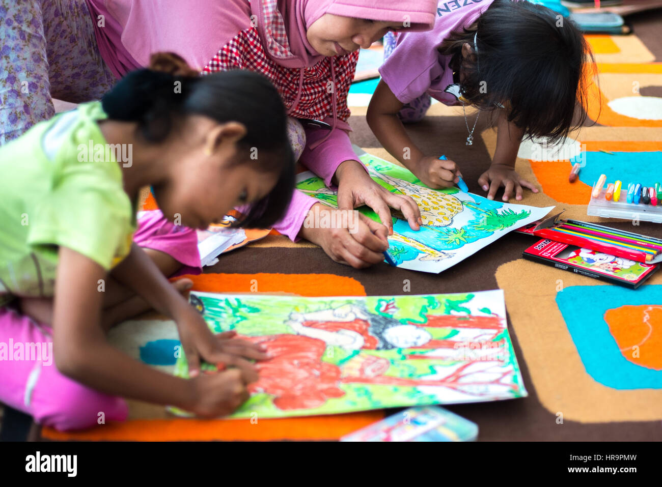 Weibliche Kinder zeichnen mit Mutter. Stockfoto