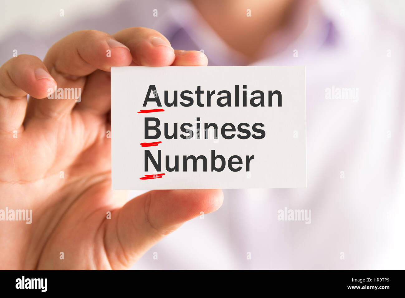 Closeup auf Geschäftsmann hält eine Karte mit ABN AUSTRALIAN BUSINESS NUMBER Nachricht, Firmen-Konzept-Image mit soft-Fokus-Hintergrund und Vintage-Ton Stockfoto