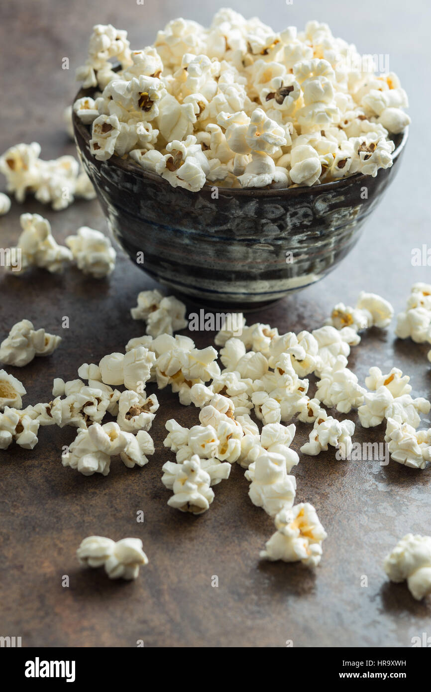 Popcorn in Keramikschale auf rostigen Hintergrund. Stockfoto