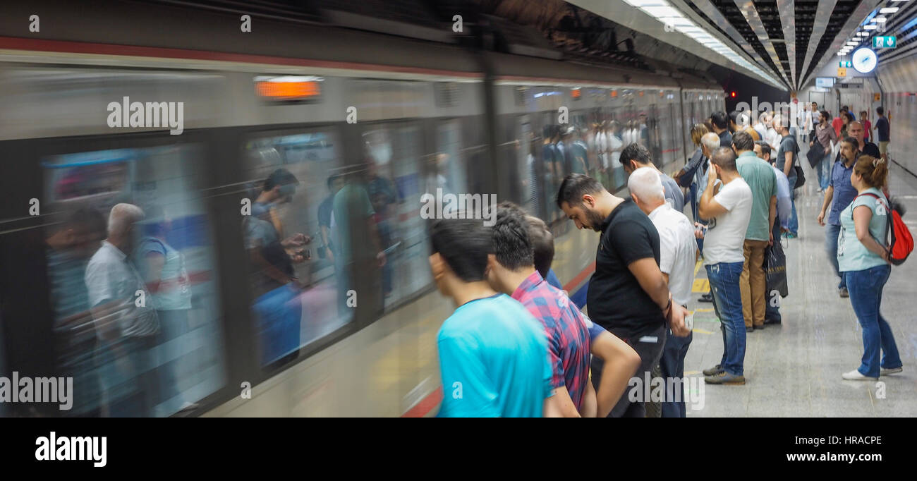 PASSAGIERE AUF PLATTFORM ZUG ZU KOMMEN, UM HALT WARTEN STEHEND, MARMARAY BAHNHOF PLATTFORM-ISTANBUL-TÜRKEI Stockfoto