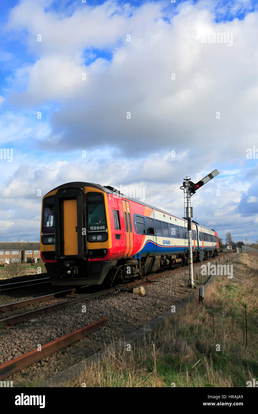 East Midlands Trains, 158856 vorbei an einem unbeschrankten Bahnübergang, whittlesey Stadt, Flussauen, Cambridgeshire, England. Stockfoto