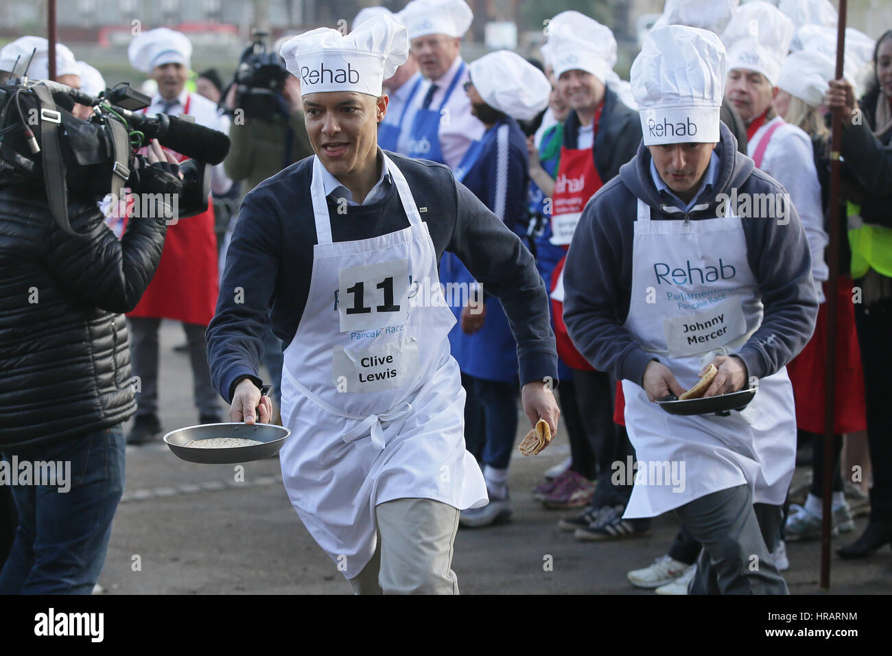 London, UK. 28. Februar 2017. M/s Clive Lewis (L) und Johnny Mercer nehmen Teil in der Reha parlamentarischen Pancake Race in Victoria Tower Gardens in London, Großbritannien am 28. Februar 2017. Das jährliche Rennen am Faschingsdienstag ist ein Relais zwischen m/s, Lords und Medien und sammelt Geld für die Reha-Behinderung-Charity. Bildnachweis: Tim Irland/Xinhua/Alamy Live-Nachrichten Stockfoto