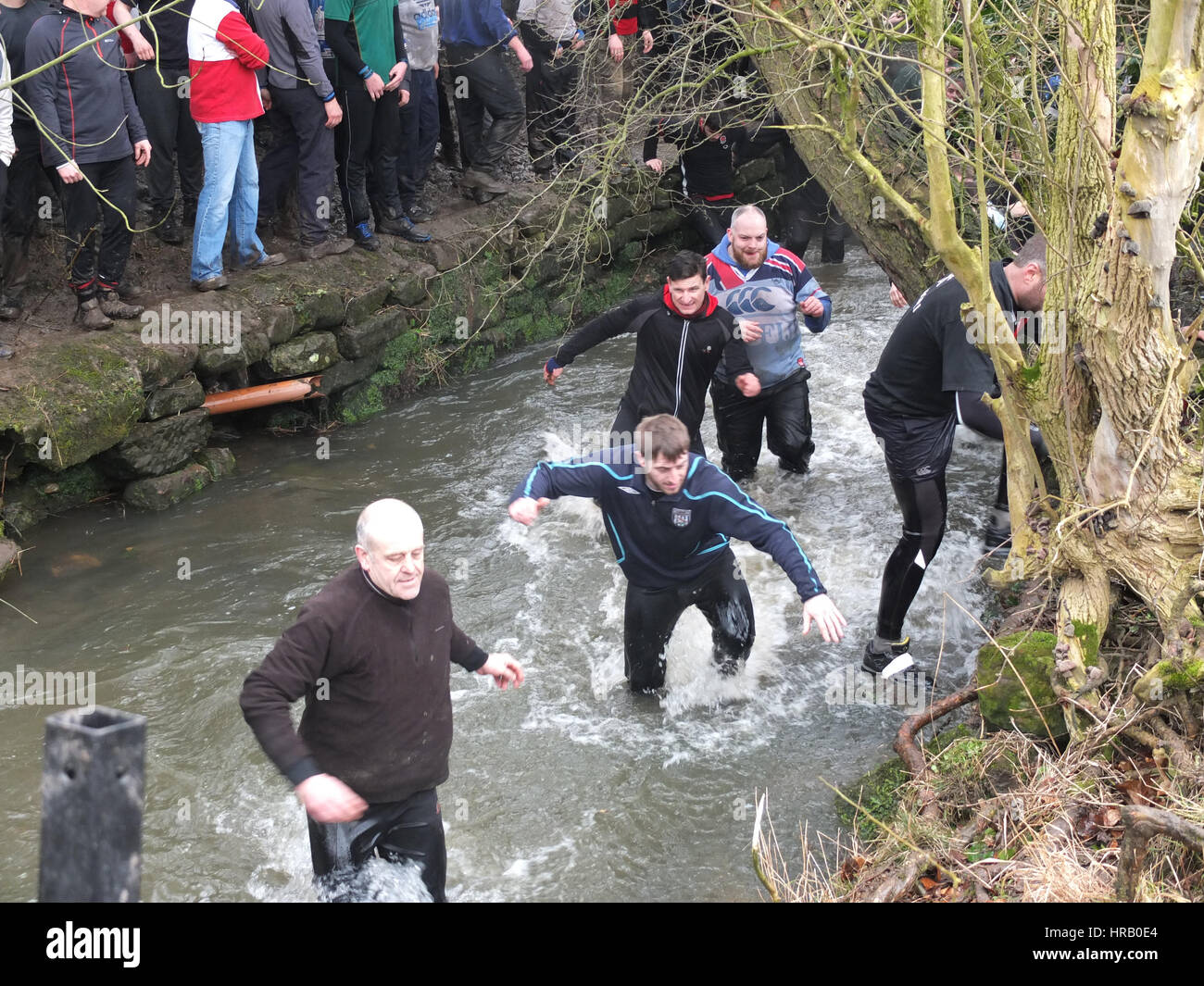 Ashbourne, Derbyshire, UK. Der jährliche Rumble zwischen Uppards und Downards, die Ashbourne Royal Fasching Footabll stattfinden wird. Im Wesentlichen ein riesiges Rugby Gedränge, die über die ganze Stadt stattfindet, müssen die Spieler Tor den Ball an einer der zwei Tore und welches Team man spielt hängt davon ab, ob Sie nach oben geboren wurden oder nach unten von der Henmore-Bach, der durch die Stadt schwärmen. Das ganze findet wieder statt morgen (1. März), Aschermittwoch. Spieler, die kriechen, um aus dem Henmore Bach, den Ball zu folgen. Stockfoto